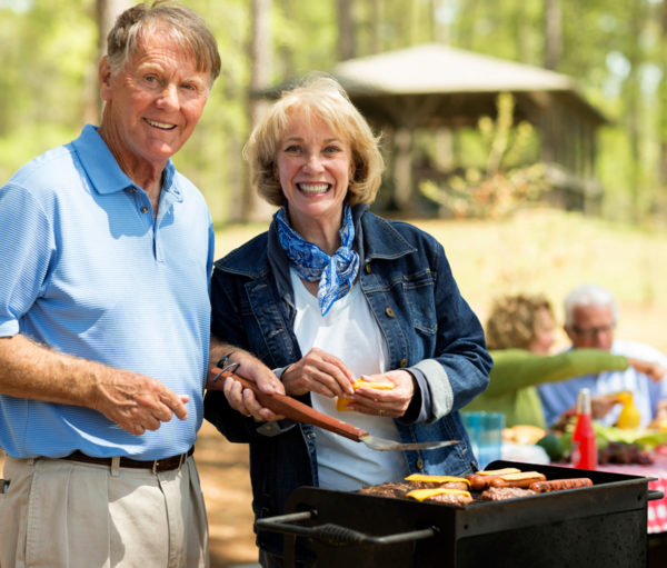 Sminling couple with barbeque grill