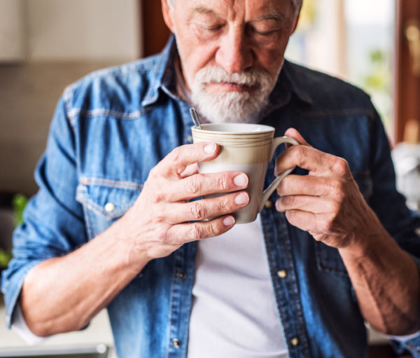 Senior man smelling cup of coffee